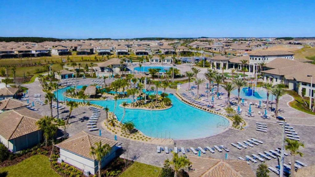Complejo de piscinas de estilo tropical y cabañas en una comunidad de alquiler vacacional en Orlando.