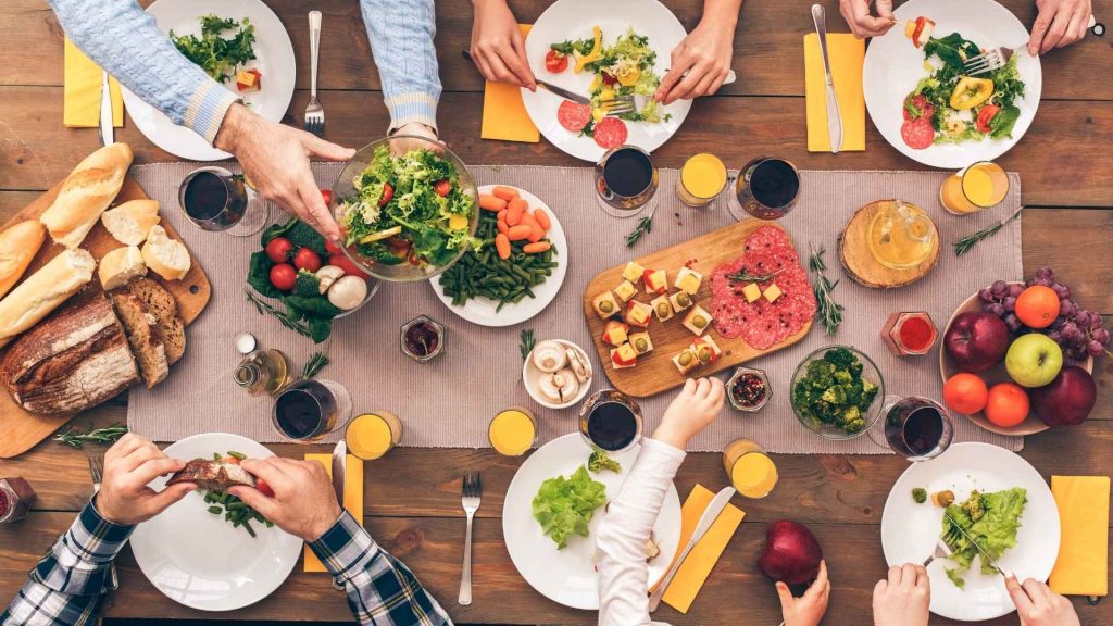 familia reunida en la mesa compartiendo los alimentos
