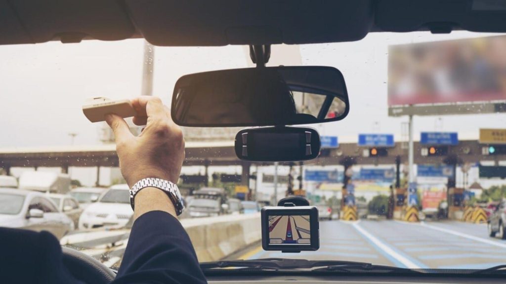 Conductor pegando sensor de sunpass al panoramico