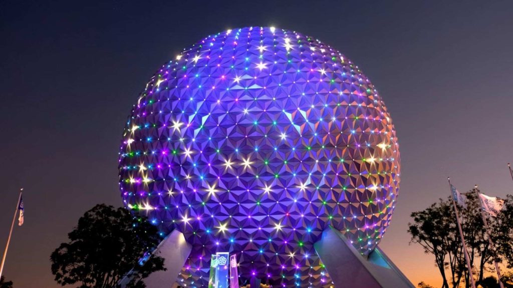Spaceship Earth iluminada de noche en EPCOT, Walt Disney World Orlando, destacando el show de luces Beacons of Magic.