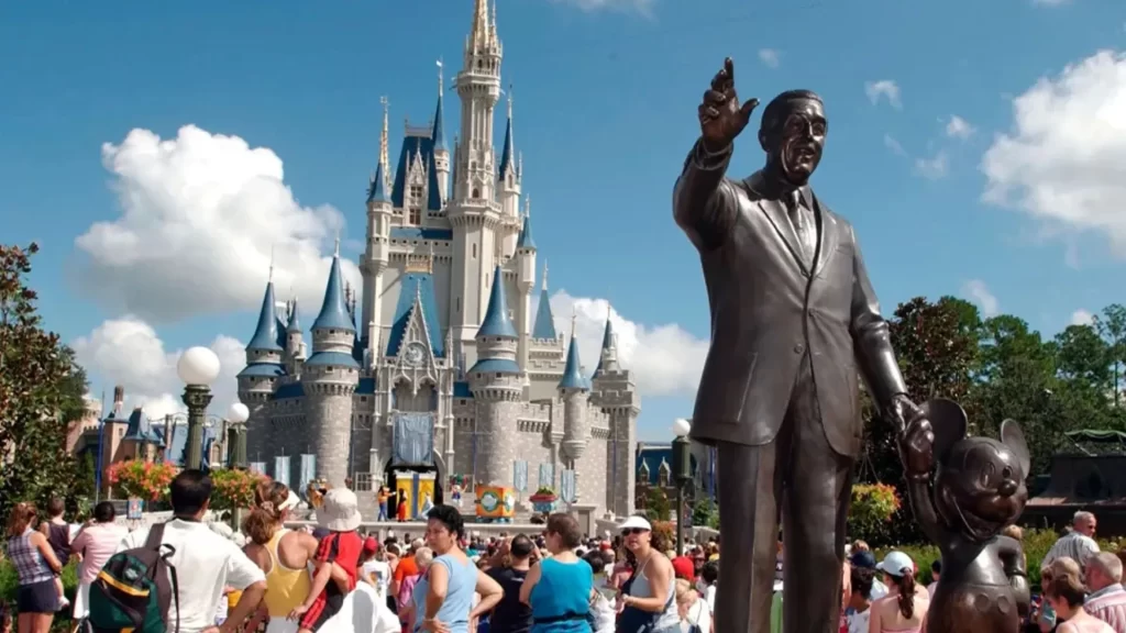 Estatua de los fundadores frente al castillo de Magic Kingdom con visitantes en Disney World, Orlando, Florida