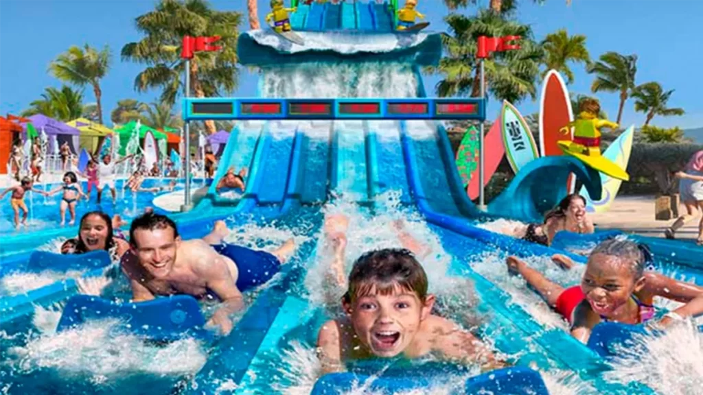 Niños y adultos bajando toboganes en el parque acuático de un resort vacacional en Orlando.