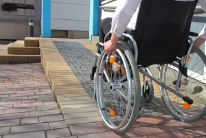 Persona en silla de ruedas usando rampa de acceso en casa vacacional accesible en Orlando.
